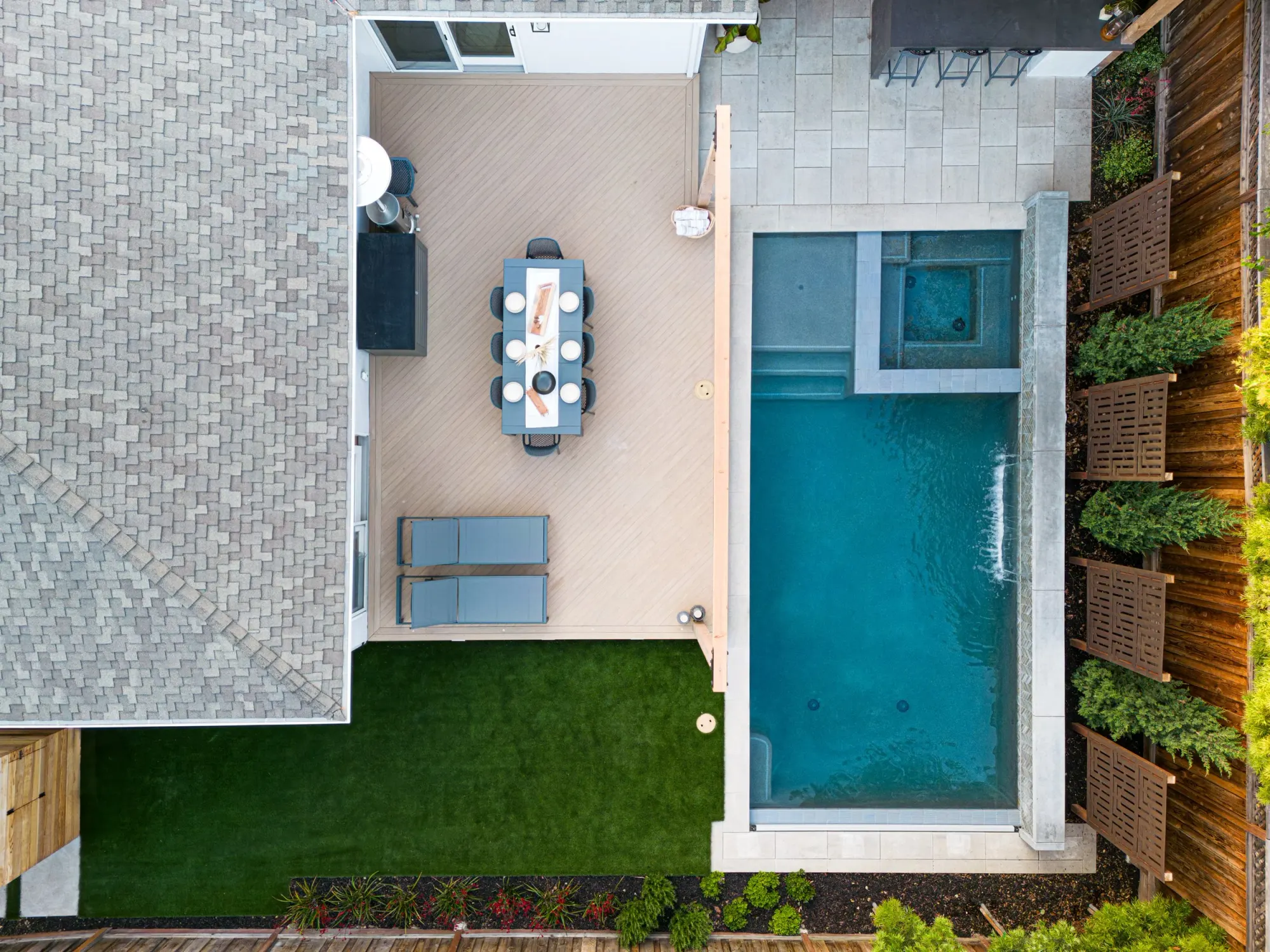 Aerial view of a narrow pool yard with a paver terrace