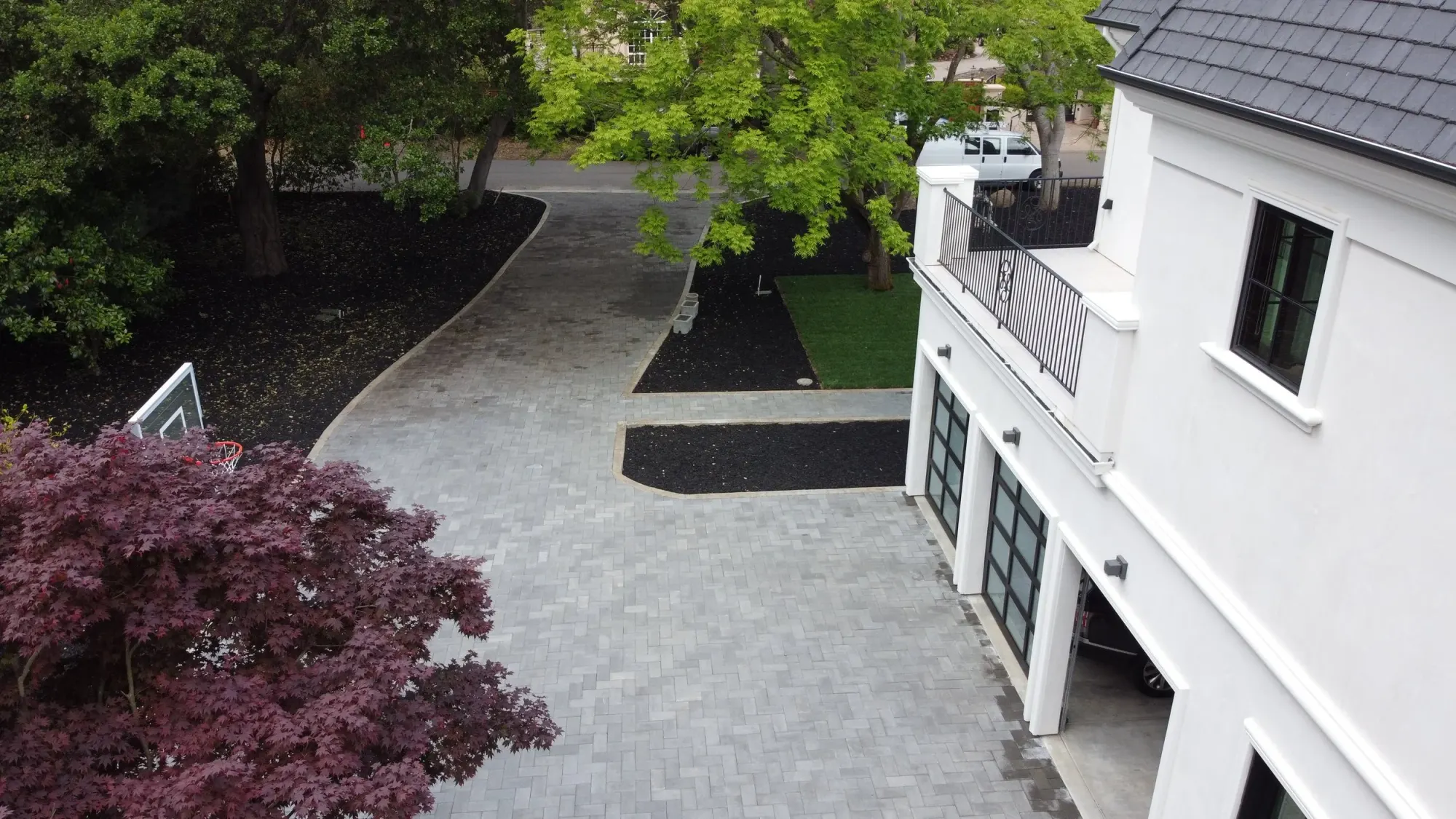 Aerial view of a paver drive running beside a house