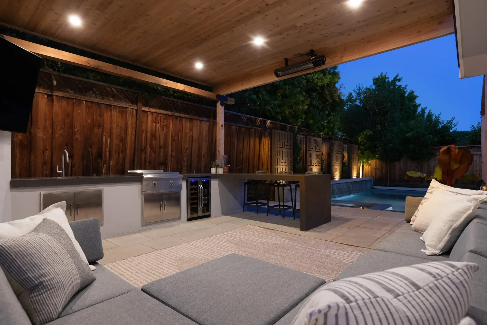 Covered lounge beside an outdoor kitchen