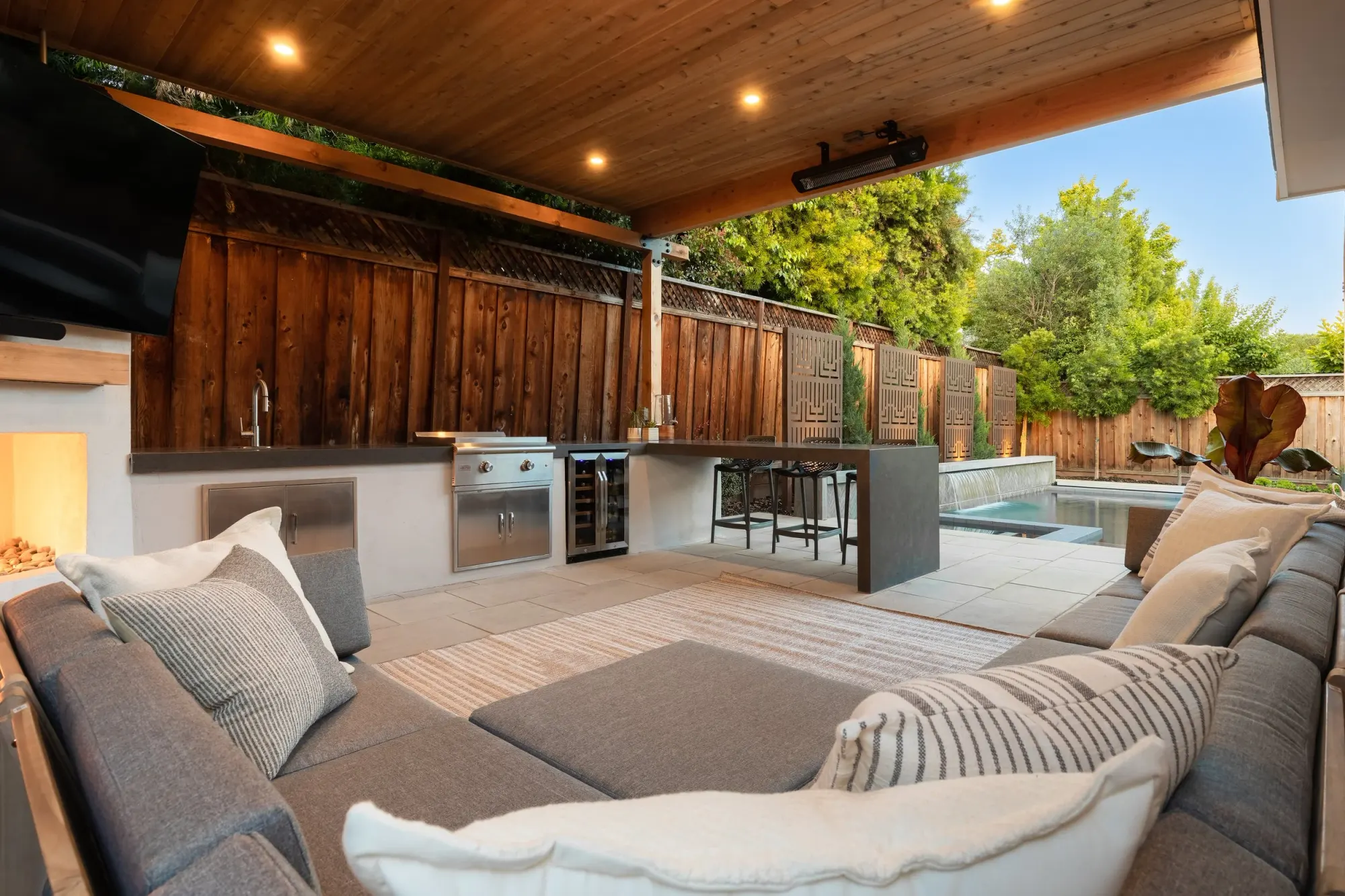 Covered lounge with a fireplace and outdoor kitchen