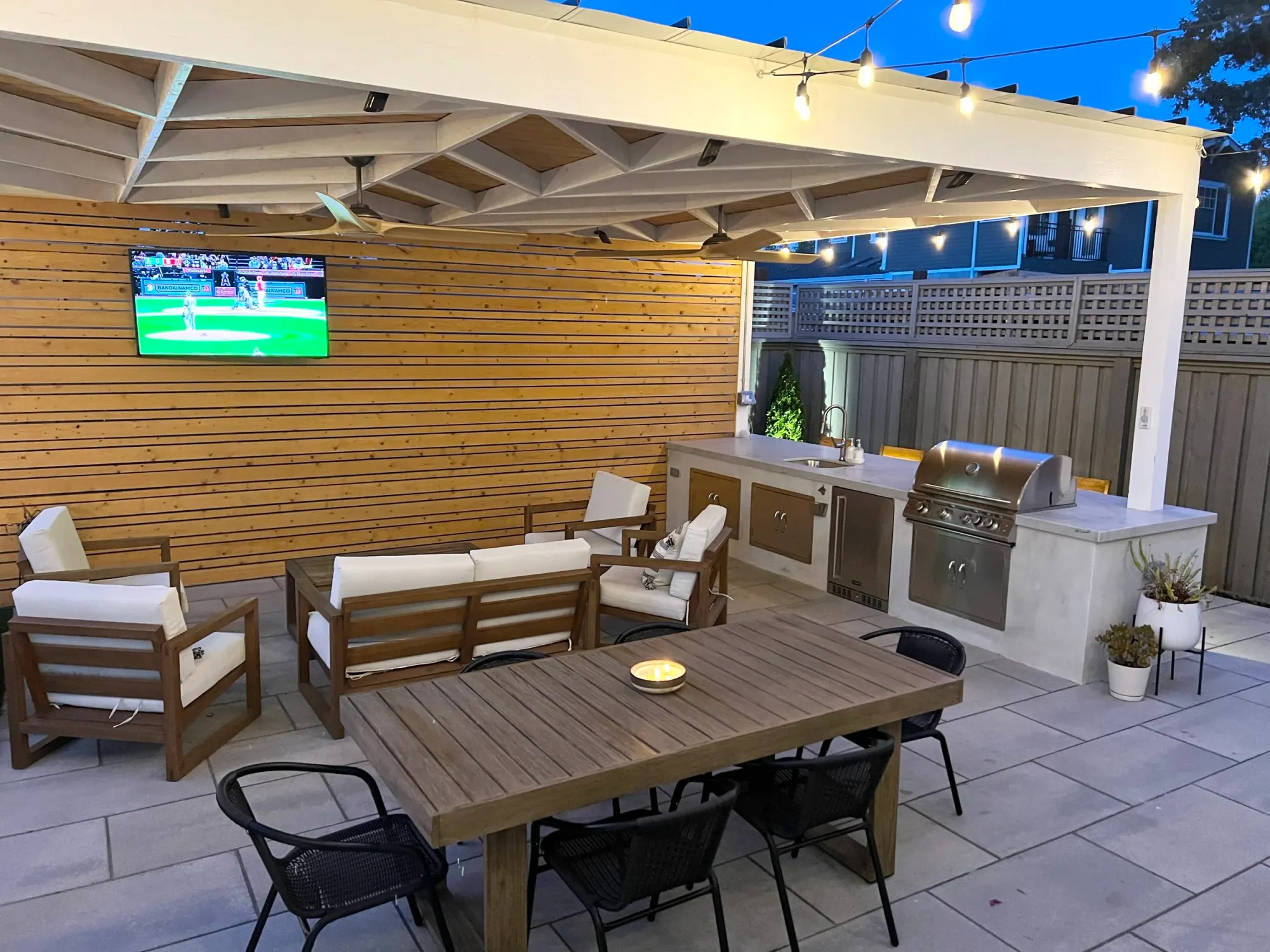 Covered patio with a TV wall and kitchen