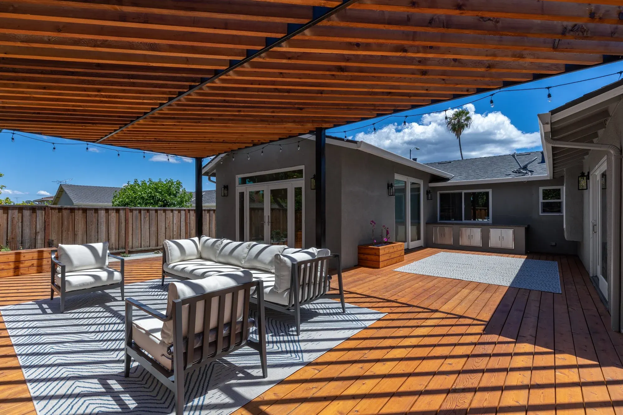 Deck stepping down to a paver lounge under a pergola
