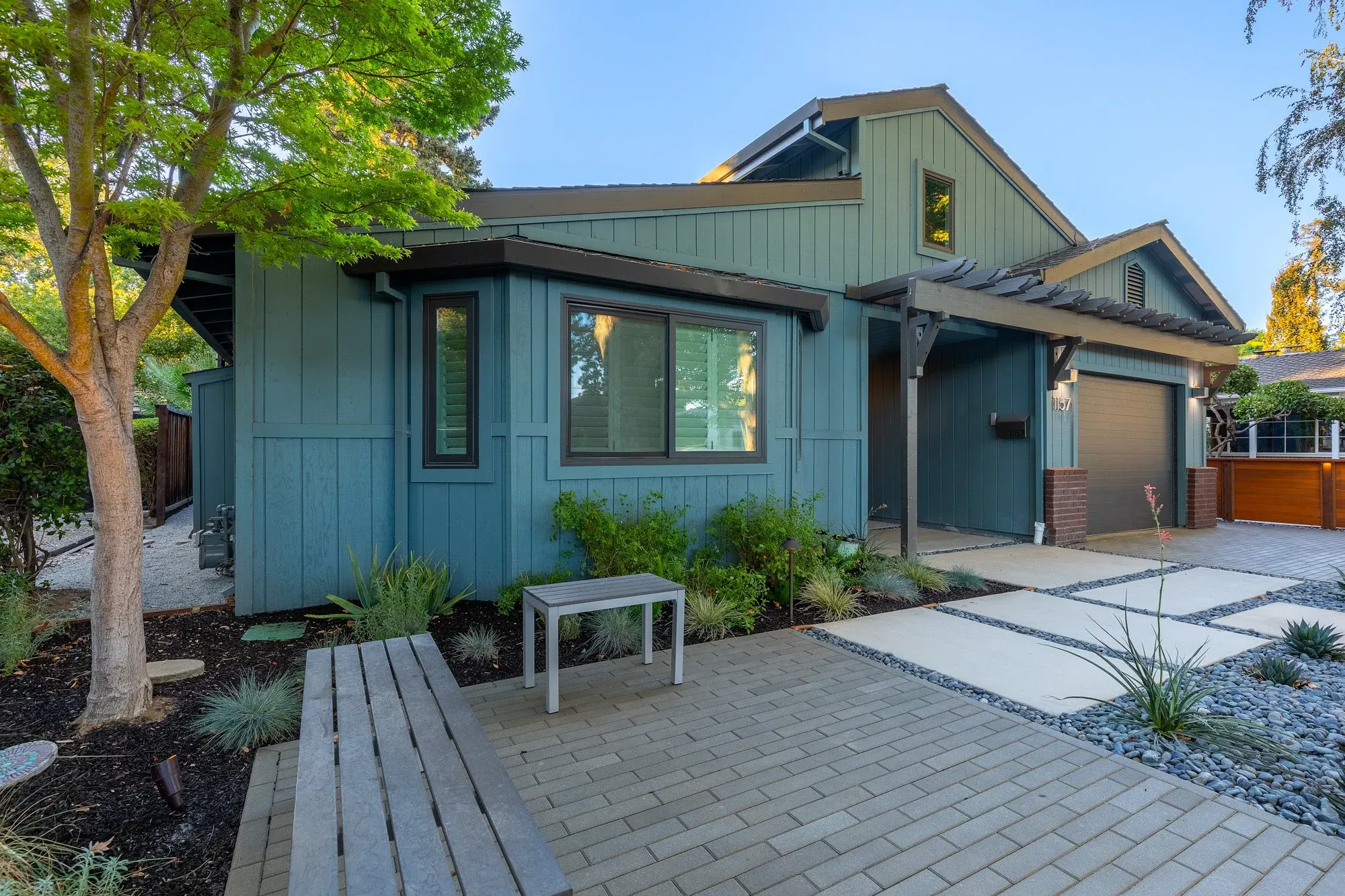 Front yard paver court surrounded by plantings