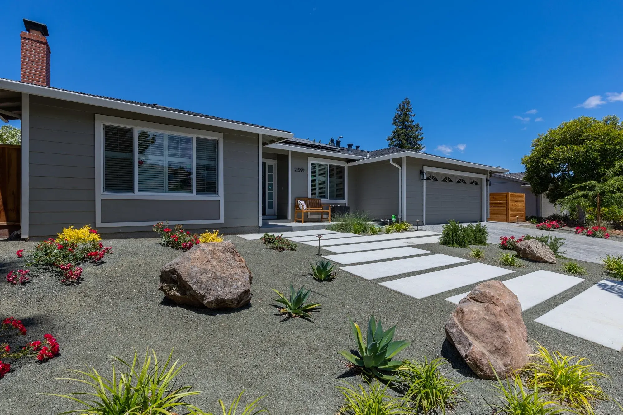 Front yard with boulders and stepping slabs set into planting