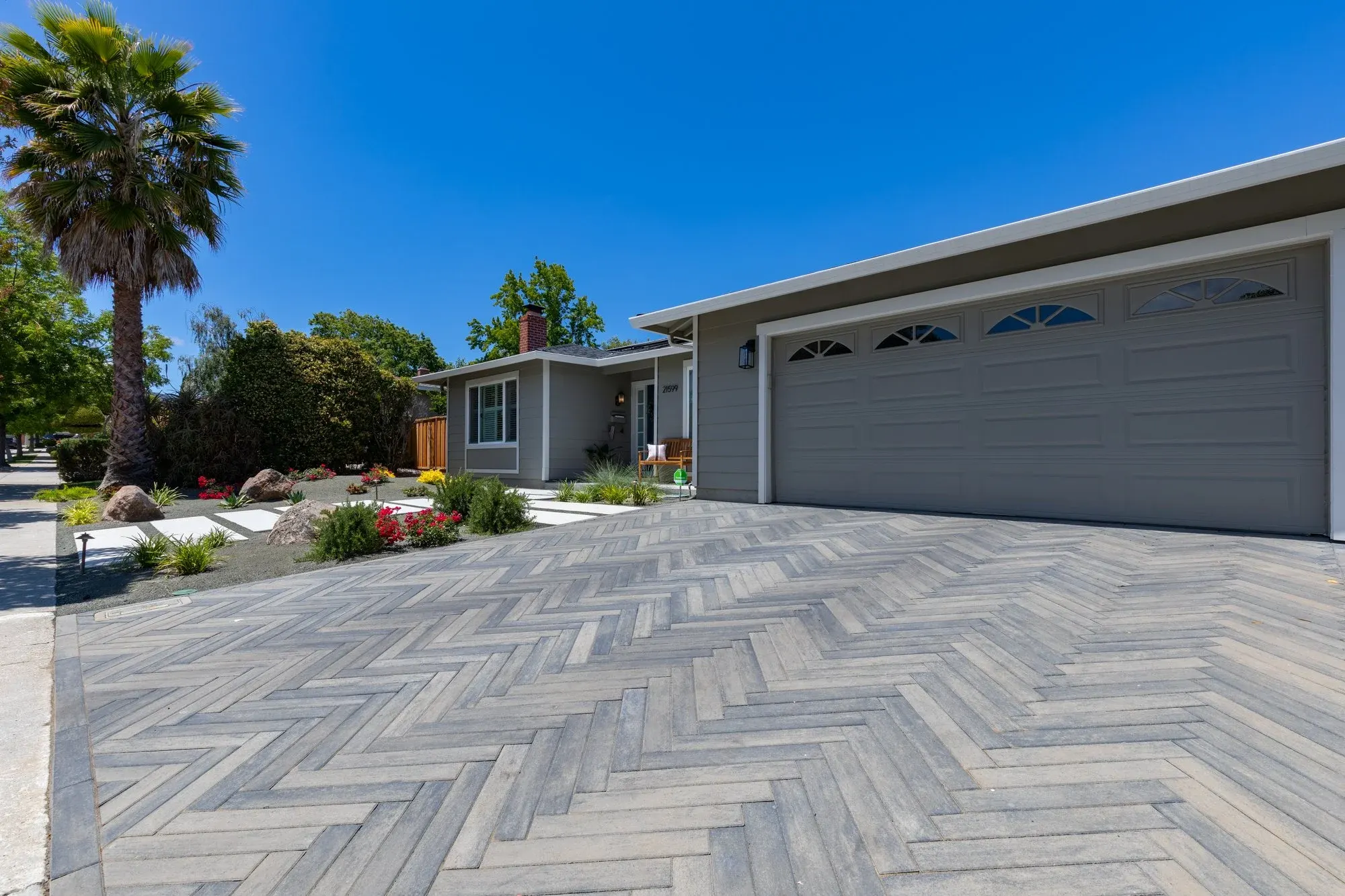 Herringbone paver driveway in front of a garage