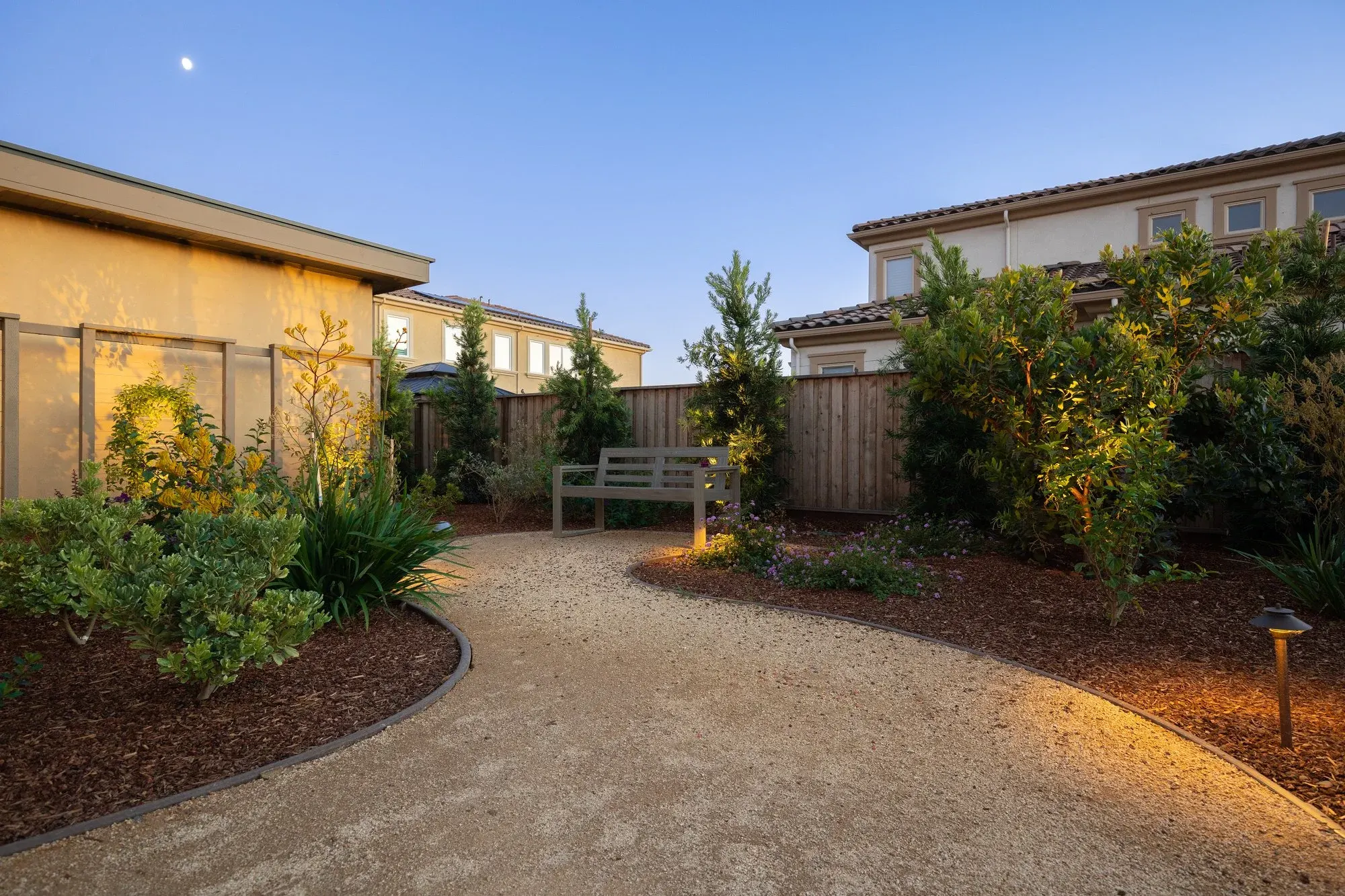 Gravel garden path with path lights at dusk