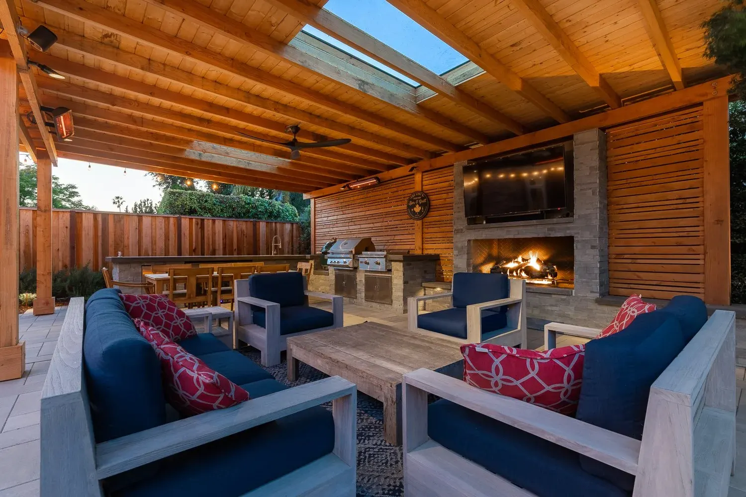 Covered outdoor room with a fireplace and a TV wall