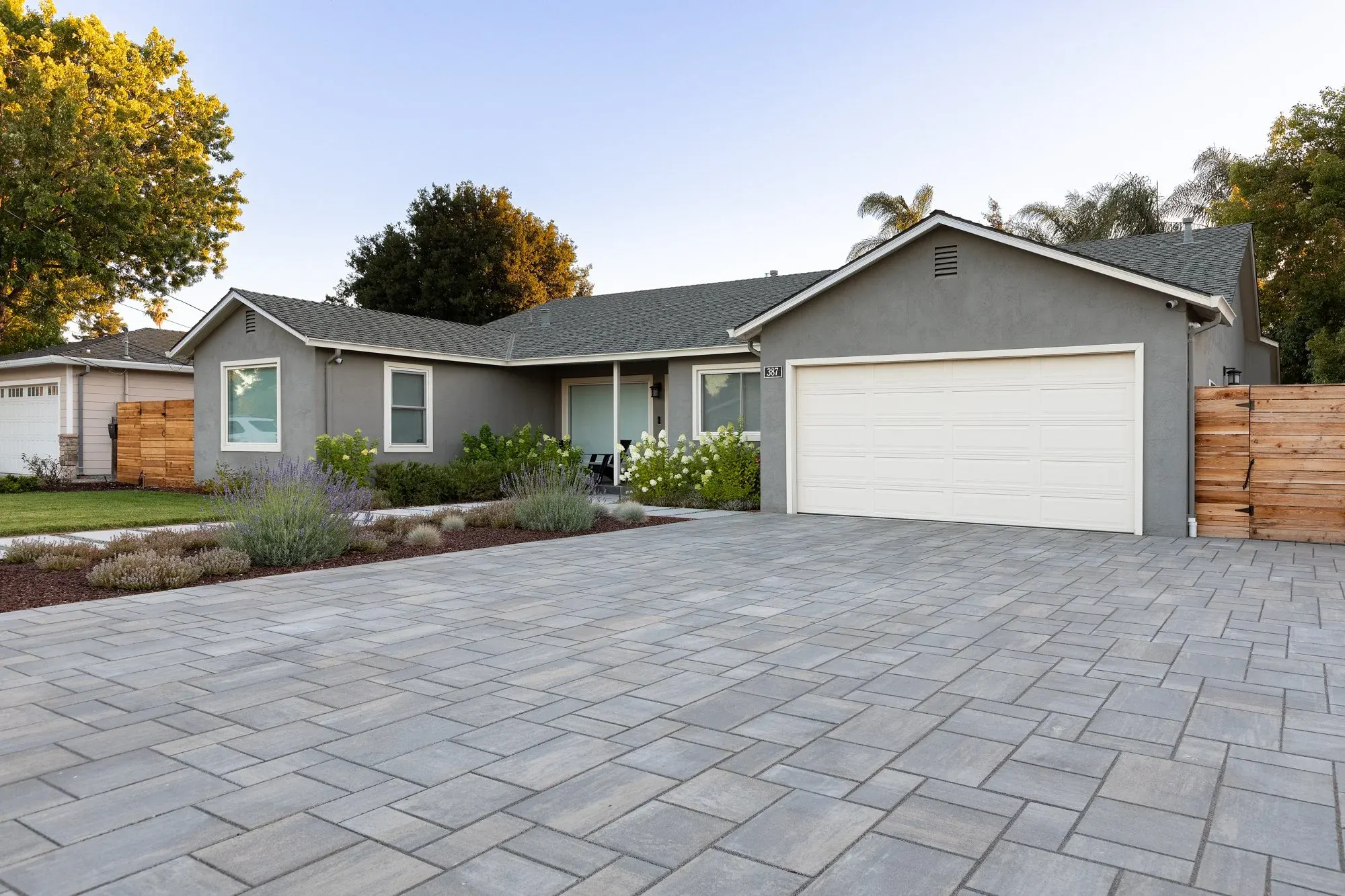 Paver driveway leading up to the front of a two-story house