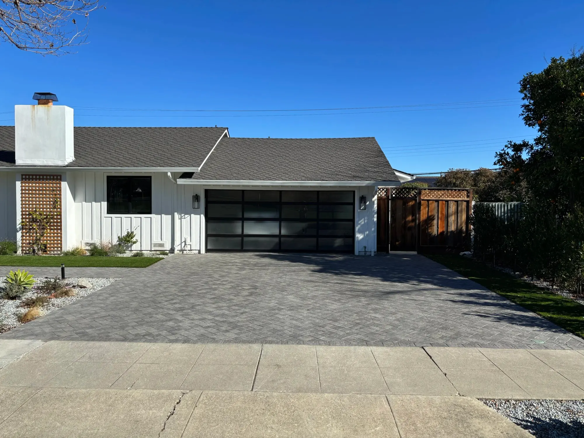 Paver driveway in front of a dark garage door