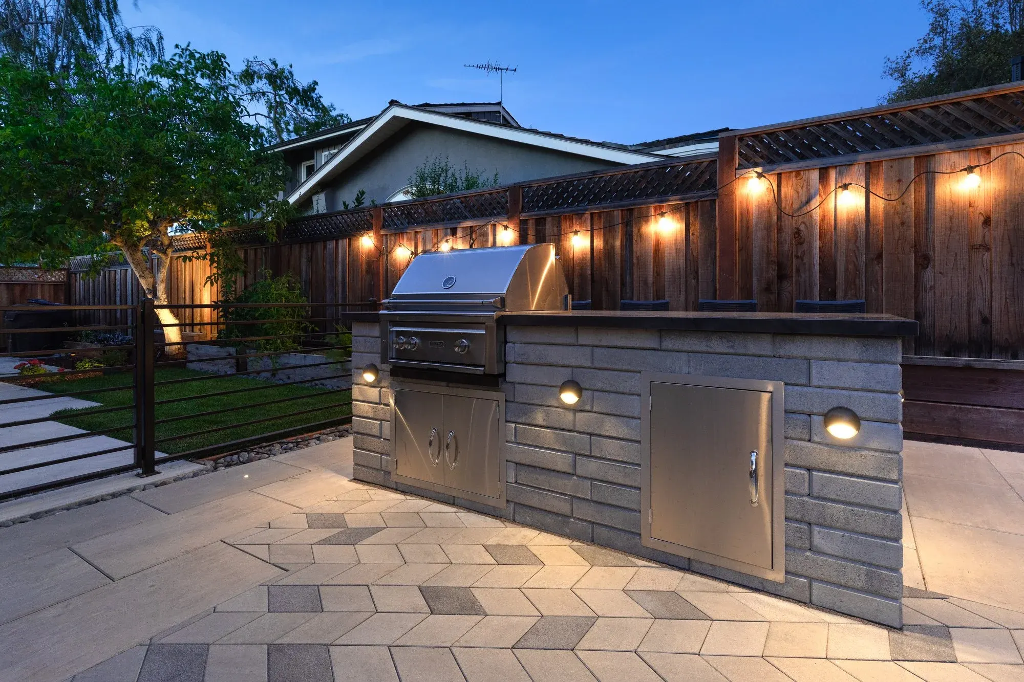 Stone outdoor kitchen under string lights