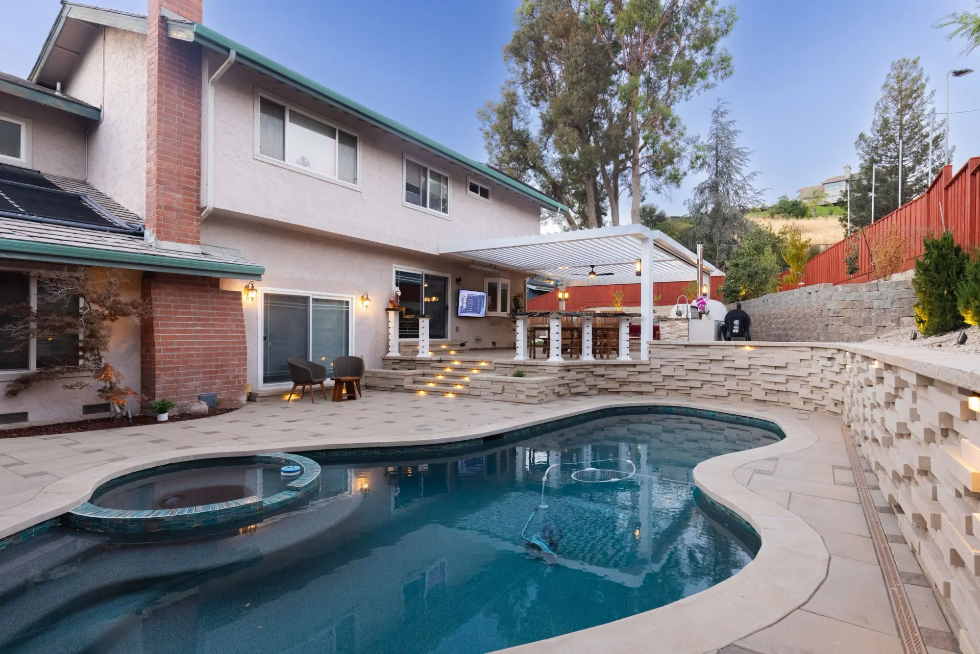Travertine pool deck with a raised spa